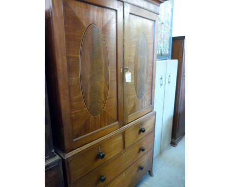 A George III mahogany linen press, with oval panelled doors, and supported on splay bracket feet.  203cm H