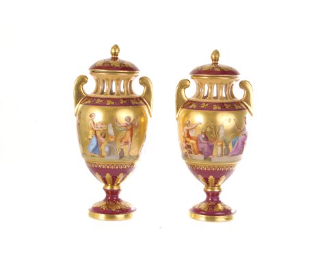 A pair of ceramic Vienna vases and covers, the burgundy glaze heightened in gilt, each with neo-classical scene decoration (4