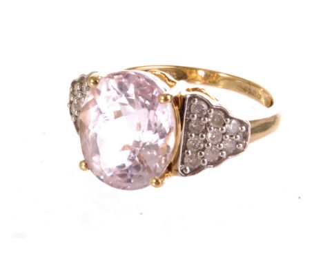 An 18ct gold pink topaz and diamond ring, the large pink topaz set in claw mount, flanked by small diamonds set in the form o