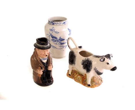 A Royal Doulton Winston Churchill jug, together with a ceramic cow creamer, a blue and white ovoid vase depicting flying bird