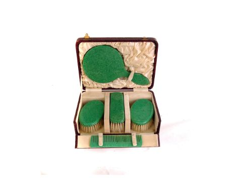 A vintage cased dressing table set,  comprising three brushes, a hand mirror and comb