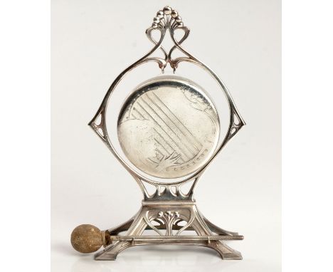 The circular gong depicting a woman playing the harp suspended within a shaped frame raised on four feet, the gong with leath