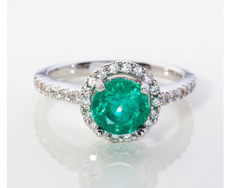 Claw set to the centre with a round mixed-cut emerald weighing approximately 0.81ct, the conforming surround and shoulders em