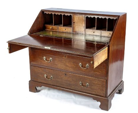The rectangular top above a hinged fall-front enclosing drawers and compartments, in sizes, above a gilt-tooled leather inset