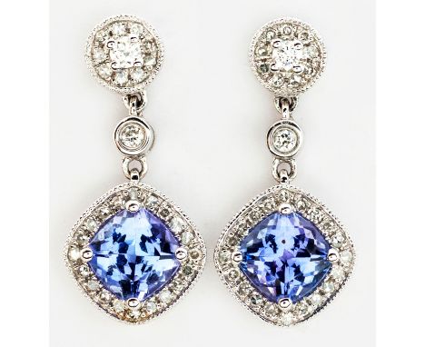 Each claw set with a cushion-cut tanzanite weighing approximately 1.34ct in total, the conforming surround and circular surmo