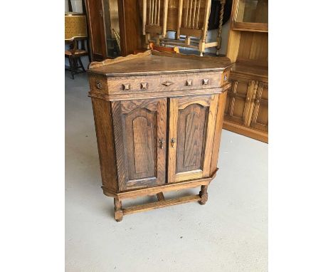 Oak corner unit with two panelled doors enclosing one fixed shelf together with a sewing chair H102cm W78cm D49cm