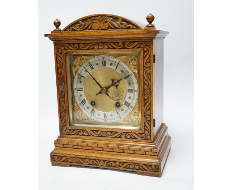 An Edwardian carved oak mantel clock with engraved dial, 33cm high