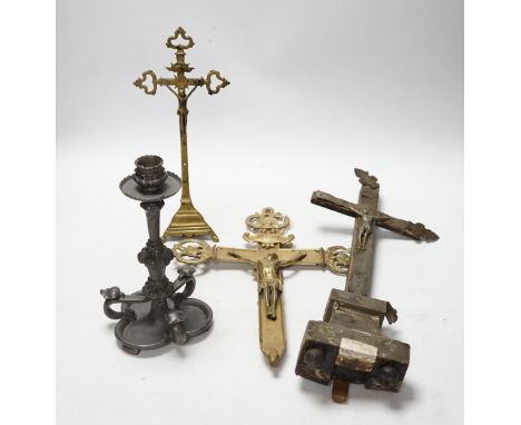 Three brass crucifixes and an Orivit pewter candlestick, tallest 45cm high