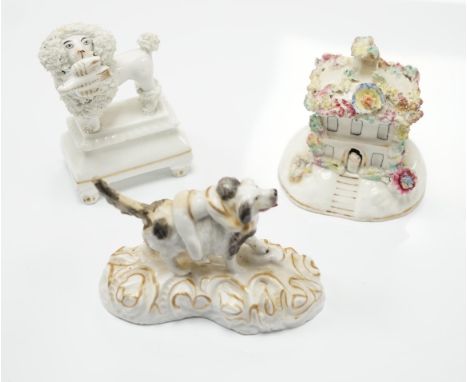 Three Staffordshire porcelain dog figures, c.1830-50, comprising a boy clinging to the back of a spaniel, a model of a poodle