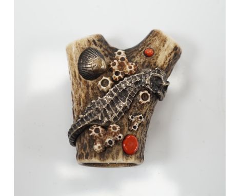 A Japanese coral and mixed metal mounted stag antler netsuke, 19th century, the antler carved in imitation of rocks applied w