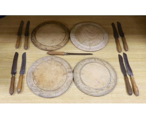 Four carved wood bread boards and a collection of knives with carved handles, boards 28cm in diameter One board less-used tha