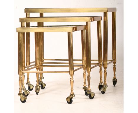 A vintage 1980s Hollywood Regency brass nest of table. The nesting tables, graduating in size having inset smoked glass tops 