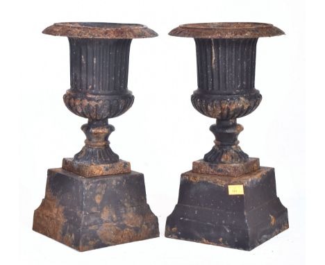 A pair of vintage 20th century black painted cast iron outdoor decorative urns. Each urn of Neoclassical form with fluted des