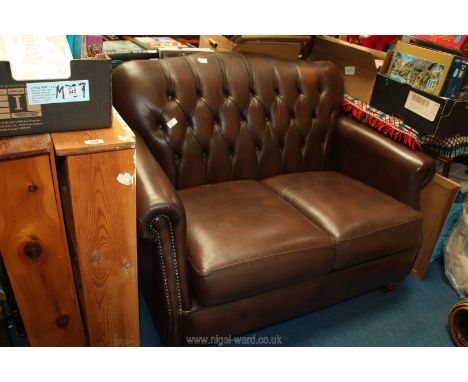 A Thomas Lloyd brown leather two seater button back sofa.