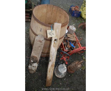 A wooden water butt with tools, plastic tray of tools and saddle racks.