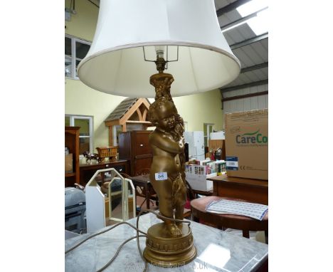 A cherub style table lamp with large shade.