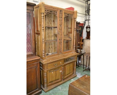 A 20th century pine dresser, carved panel to top, turned supports, pair of drawers over pair of cupboard doors to base. 228cm