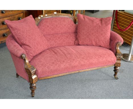 A mid-19th century mahogany sofa, shaped and carved cresting rail, curved padded arms, stuffed-over seat, turned forelegs, ce