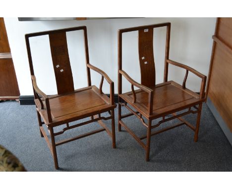 A pair of oriental hardwood armchairs, S-form splat, shaped open arms, panel seat, cylindrical supports, H-frame stretchers.