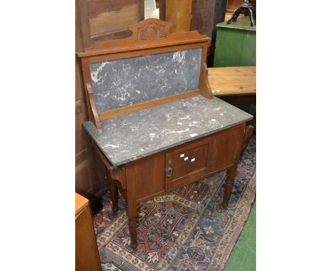 A mahogany washstand, marble top and back, single door cupboard to base, turned supports, ceramic casters.