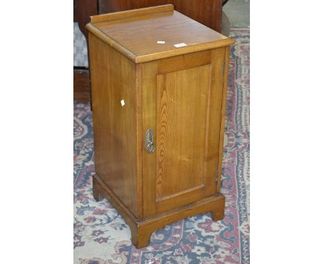 An ash bedside cabinet, galleried top, panel door