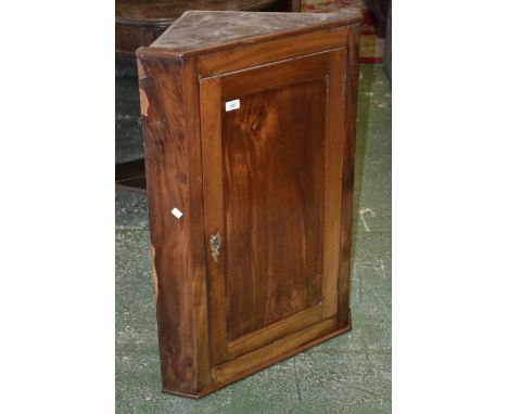 A mahogany wall mounted corner cupboard, canted angles, panel door enclosing shelving. 91cm high x 64cm wide