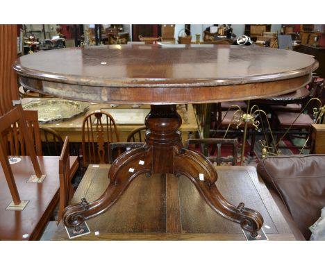 A mahogany loo table, circular top, turned column, three hipped sabre legs, ceramic castors