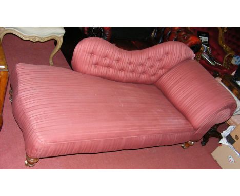 A Victorian chaise longue with button back armrest standing on turned supports 