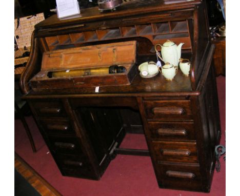 A 1920's oak roll-top desk with drawers to the front and fitted interior 