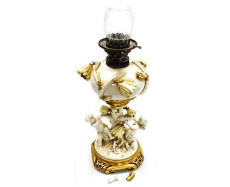 A late 19thC Moore Brothers porcelain oil lamp base, the white glazed reservoir encrusted with flower and leaves, on a trunk 