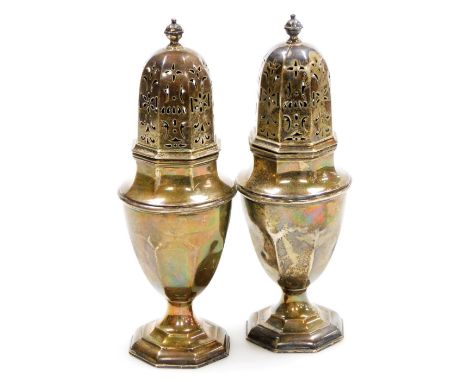 A pair of George V silver sugar castors, each with an orb finial, pierced lid and shaped body on a stepped foot, one with pre