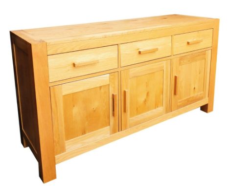 A modern light oak sideboard, with three frieze drawers above three hinged cabinets, raised on stiles, 86cm high, 160cm wide,