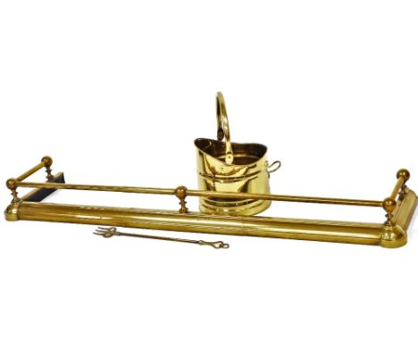 A brass fire fender, 135cm wide, a brass coal bucket, 21cm high, and a toasting fork, with pierced heart shaped handle. (3)