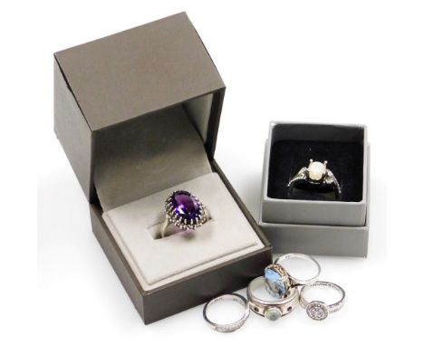 Six silver and other dress rings, comprising a purple paste stone and marquisette cluster ring, a crossover ring, aquamarine 