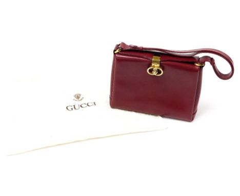 A vintage Gucci red leather top handle bag, with gold coloured double G turn lock clasp, the interior revealing three section