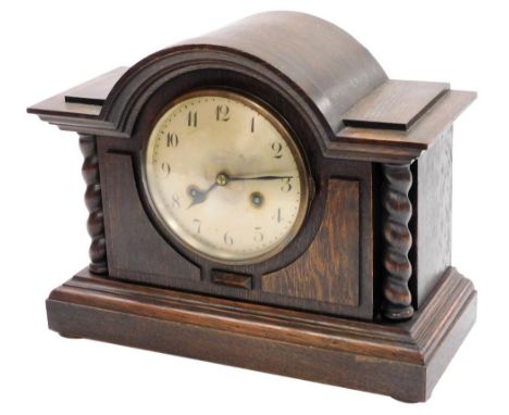 An oak cased mantel clock, with Arabic numeral silvered dial, eight day movement with coil strike, the case of architectural 