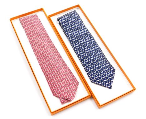Two Hermes silk ties, comprising a red tie with linked design, and a blue tie with horse bit link design, both boxed.