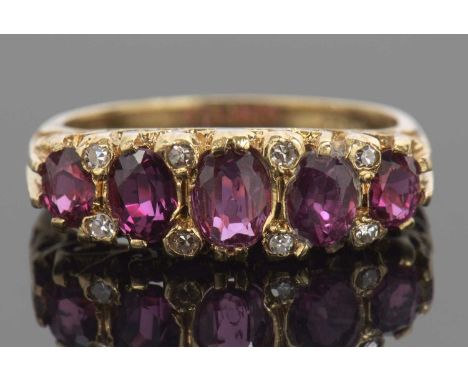 Victorian garnet and diamond ring featuring five graduated oval cut garnets, highlighted between with small diamonds all in a