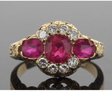 Ruby and diamond triple cluster ring featuring a cushion cut ruby, two oval rubies and eight round brilliant cut diamonds, th