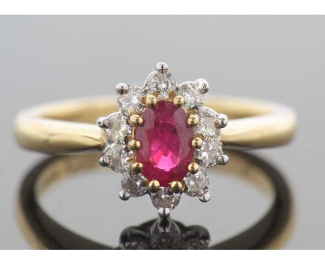 18ct gold ruby and diamond cluster ring, the oval faceted shaped ruby raised above a diamond surround, diamond total ct wgt 0