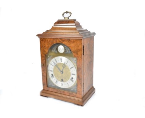 An Elliott bracket style clock in a walnut case, the brass dial with a silvered Roman chapter ring, cherub spandrels and foli