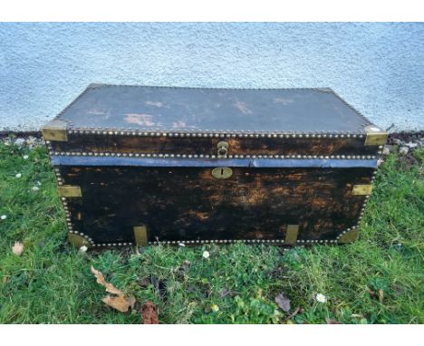 A studded black leather brass-bound twin-handled trunk, 93 cm wide x 46 cm deep x 43 cm high