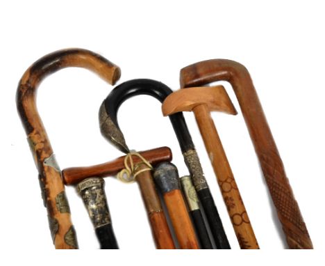 A collection of walking sticks, including an early 20th Century ebonised example with silver mounts; an ebonised swagger stic