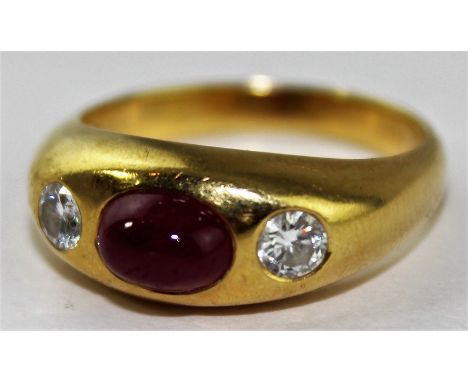 An 18ct. yellow gold, ruby and diamond ring, having central oval cabochon ruby flanked by single round cut diamonds in burnsh