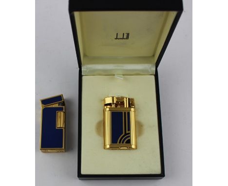 A Dunhill gold plated and blue enamel lighter, serial no 51380, boxed, and another similar, serial no 424878, boxed. (2)