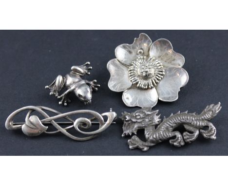 A collection of four silver brooches. to include;&nbsp;An Art Nouveau style silver openwork bar brooch, fashioned as a stylis