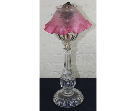 A 19th century glass oil lamp with etched cranberry shade.