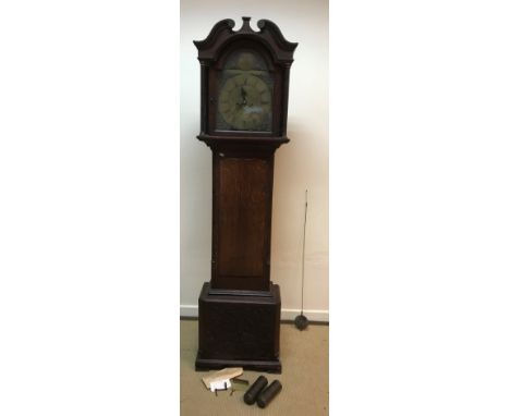 A George III oak and inlaid cased long case clock, the hood with broken arch pediment, the eight day movement with brass arch