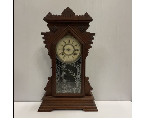 An Ansonia Clock Co. of New York stained wooden cased mantel clock with eight day movement, the case with carved decoration, 