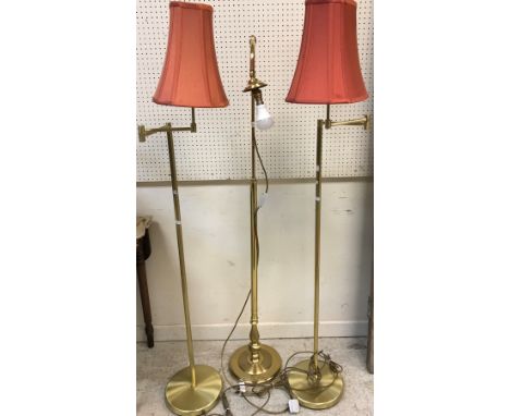 A pair of modern satin brass adjustable standard lamps and another standard lamp
